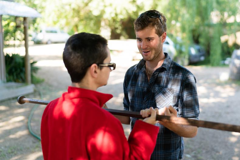 Disability worker helping man with a disability to exercise