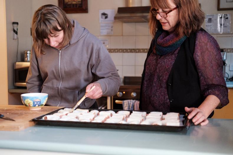 Woman with disability and disability worker making food
