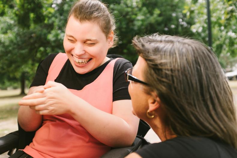 Disability worker with a person with disability in a park