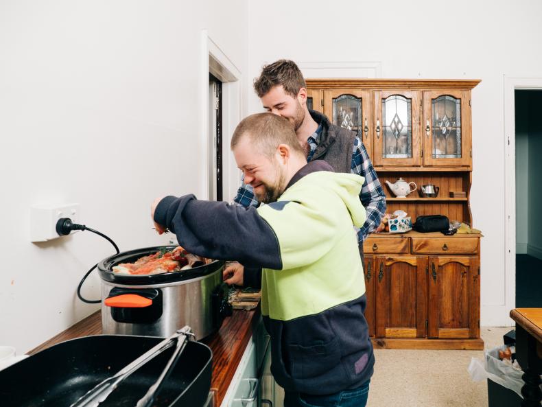 Disability worker helping a man with disability inside the house